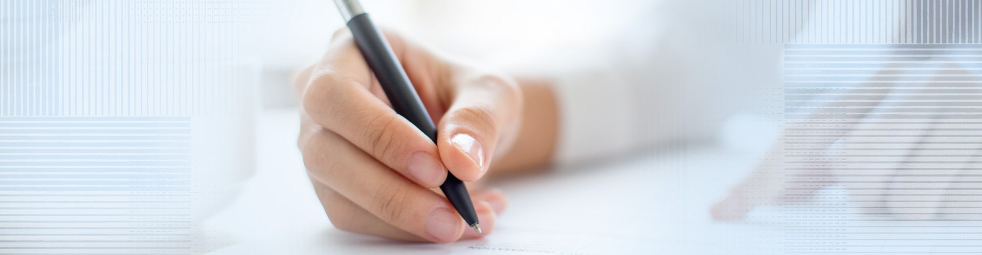 a person's hand writing a document